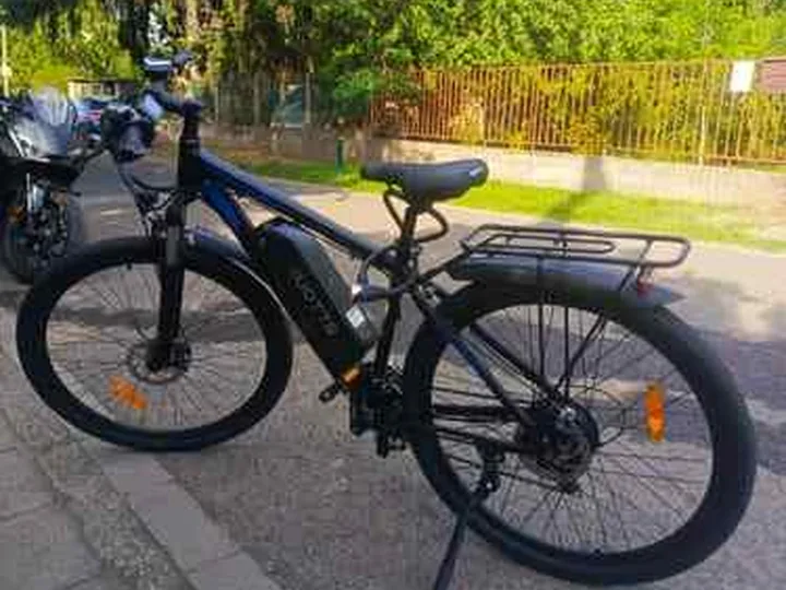 Black electric bike parked outdoors in a buyer-style scene